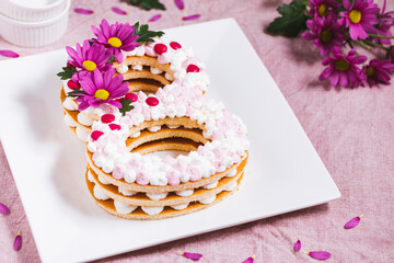 Women's day cake in the shape of number eight on pink background. 8 March concept. International women's day