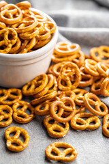 Mini pretzels. Crusty salted snack on kitchen table.