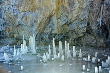 The most beautiful landscape inside the Ruskeala marble quarry in winter is a frozen lake, a frozen waterfall, ice stalagmites (stalactites) and lighting. Republic of Karelia, Russia