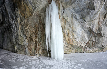 The most beautiful landscape inside the Ruskeala marble quarry in winter is a frozen lake, a frozen waterfall, ice stalagmites (stalactites) and lighting. Republic of Karelia, Russia