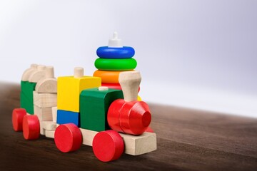 Baby kids toys background. Wooden toy train, wood stacking pyramid tower and colorful wood bricks