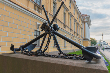 a large iron sea anchor on a granite pedestal near the walls of the naval admiralty in St....