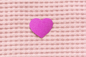 Pink hearts on a pink background. The textile background is pink.