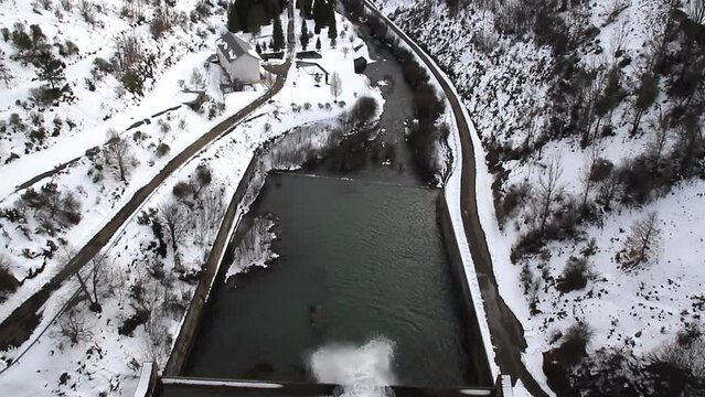  Tilt Up from the outlet of the water of a swamp to a mountainous landscape and snowy valley