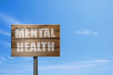 Wooden sign with phrase Mental Health against blue sky on sunny day