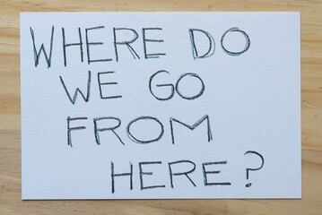 "Where do we go from here?" sign on a wooden surface