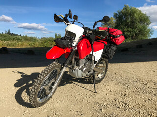 Fototapeta na wymiar Custom adventure dual sport motorcycle parked on gravel road, no brands or logos