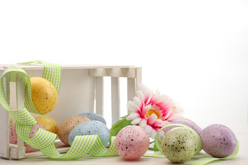 Cesto bianco in legno e uova colorate della Pasqua
