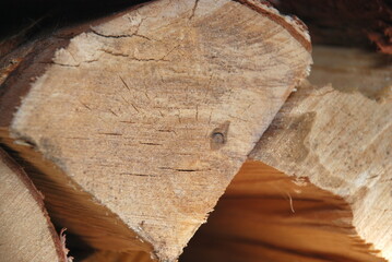 A stack of chopped firewood stacked on top of each other. Birch firewood of various shapes and sizes. stacked in several layers on top of each other. The layers are perpendicular to each other.