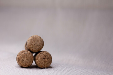 Three wine corks with a pyramid on a light background.