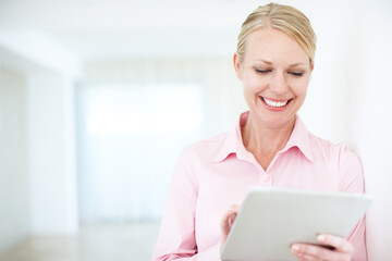 Easy access to the latest business news. An attractive businesswoman looking at something on her...