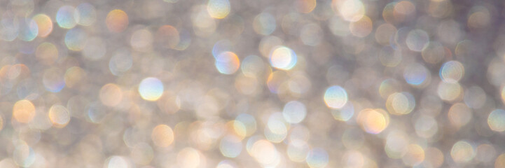 bright glitter background: bokeh effect from many colored lights on frozen glass, toning