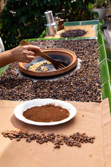 traditional roasting of coffee beans in a clay bowl, roasted beans and green beans