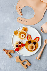 Funny food for kids. Bear and cat made of pancakes with strawberries. Idea for a baby breakfast. Top view, flat lay