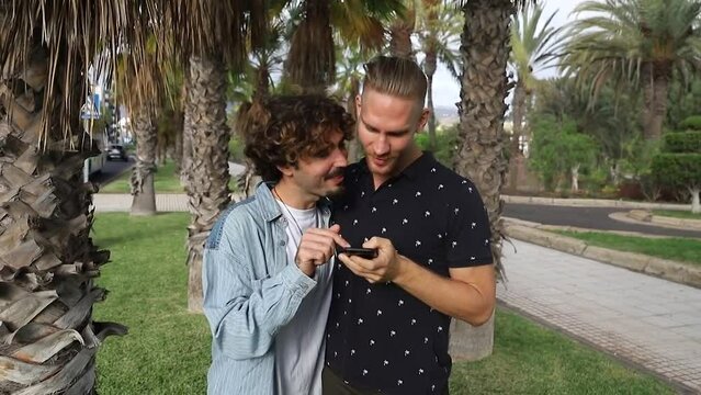 Homosexual couple takes selfies. Two gay guys happy together love each other and take pictures with the smartphone