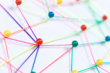 Linking entities, Blockchain, social media, Communications Network, The connection between the two networks. Network simulation on paper linked together by yarn