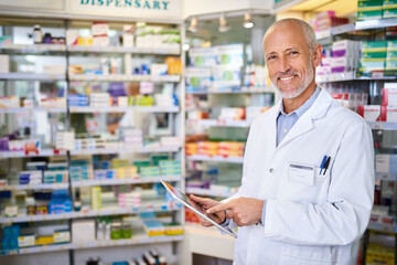 It helps me run a more efficient pharmacy. Portrait of a mature pharmacist using a digital tablet while working in a chemist.