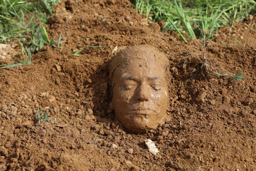 A woman buried in the ground A face covered in the ground. dead consept