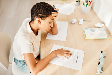 Top view portrait of African American girl struggling with homework and holding math test, copy...