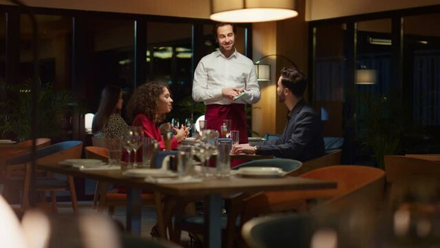 Romantic couple order waiter in expensive restaurant table on night dinner date.