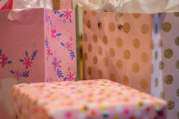 Pink gift wrapped presents in bags and packages ready for a birthday celebration.

