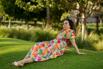 Image of a young woman in a relaxed laid back pose in the park - Powered by Adobe