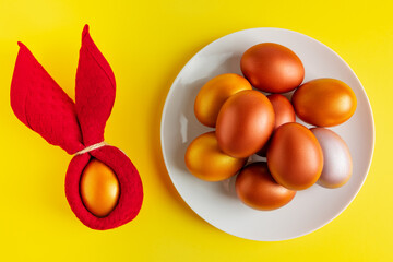 Gold glittering Easter eggs on yellow background.