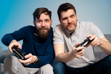 Closeup of two old school thirty year old gamers, playing game console at home 