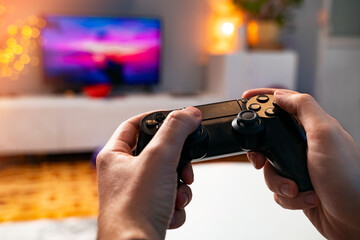 Gamers point of view, male hand holding game controller 