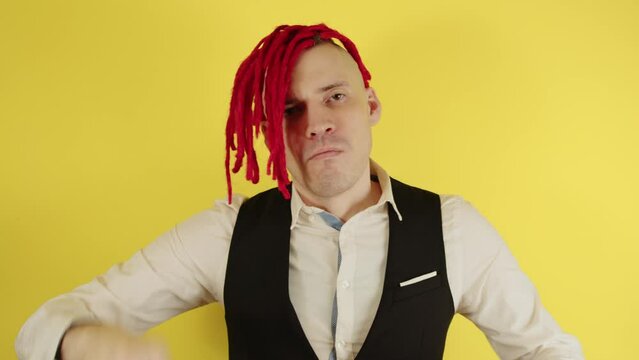 Close up of man hipster. Portrait businessman with red dreadlocks on his head throwing money banknotes, isolated bright yellow color background