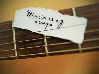 Simple text message on a small piece of ripped paper - music is my escape. With guitar background.