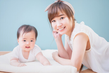 赤ちゃんと笑顔で微笑む女性
