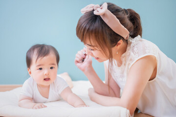 赤ちゃんと笑顔で微笑む女性
