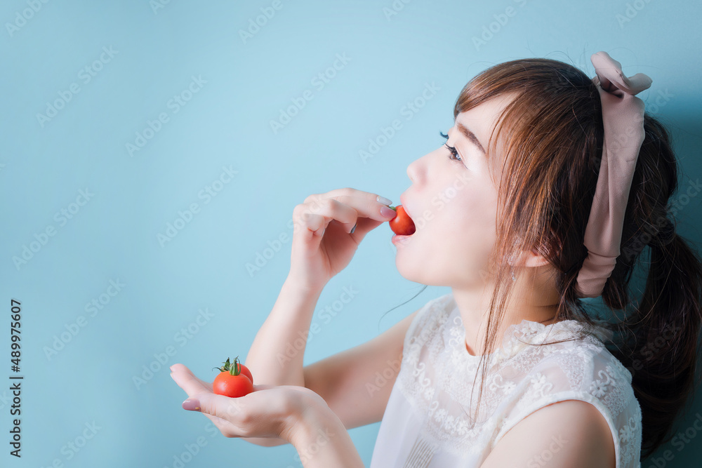 Wall mural トマトを食べる女性
