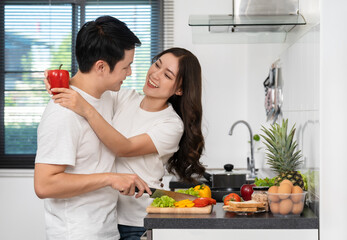 couple with preparing vegetables to cooking together in the kitchen at home. woman is hugging man