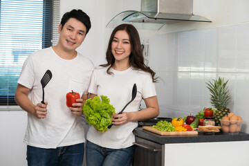 couple cooking and preparing vegetables in the kitchen at home