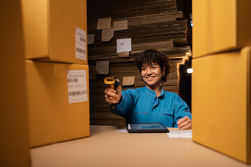 Asian woman working in storage, taking parcel and scanning barcode, putting box on shelf. Female business person at workplace in warehouse, concept of delivering and logistics. Businesswoman owner.