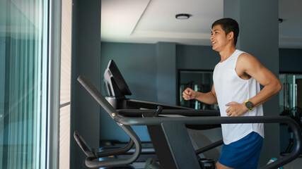 Asian men are happy jogging and running on a treadmill at gym