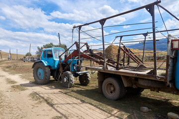 Obraz premium old tractor and hay truck in a remote village