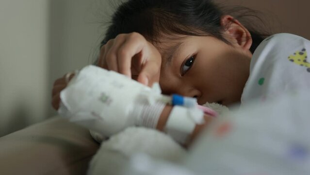 Sick asian child girl lying down on the bed at hospital