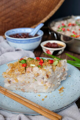 Popular street food. Homemade Steamed Taro(Yam) Cake with Red Bean Soup Dessert. Garnished with fried ground dried shrimps, scallions eaten steam or pan fried with soy and chili paste.