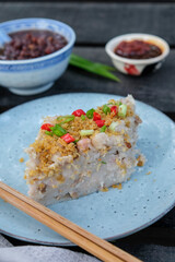 Popular street food. Homemade Steamed Taro(Yam) Cake with Red Bean Soup Dessert. Garnished with fried ground dried shrimps, scallions eaten steam or pan fried with soy and chili paste.