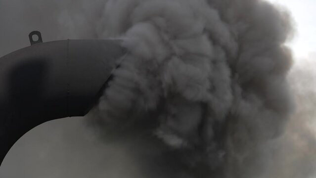 Black smoke from ferry boat flue in background, close up, Thailand. Chimney of a ferry or cruise ship, smokestack pollutes the atmosphere. Air pollution and ecology concept. Slow motion
