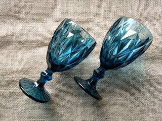 Two cups of dark blue glass are lying on a burlap