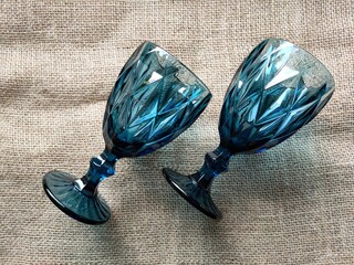 Two cups of dark blue glass are lying on a burlap