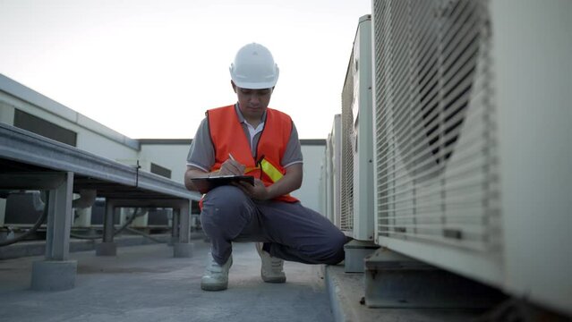 engineer sitting recheck refrigeration system factory and system operation. contractor record problem for estimate price air conditioning system and inform to customer...