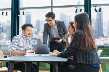 Team of young Asian entrepreneur have small team meeting for upcoming project for marketing and sale management with skyscraper view for business startup and education concept