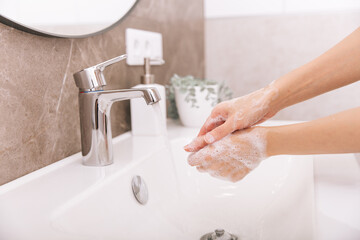 Washing hands under the flowing water tap. Hygiene concept hand detail. Washing hands rubbing with soap for corona virus prevention, hygiene to stop spreading corona virus in or public wash room.