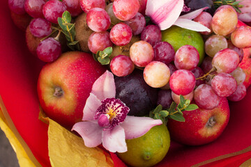 Fruity bouquet of red apples with plums, grapes, pomegranate, lime and pink orchids. High quality photo