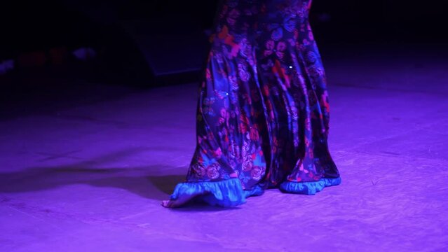 A woman's Indian outfit on a dancing girl. An Indian dancer dances an Indian dance. Lower torso.